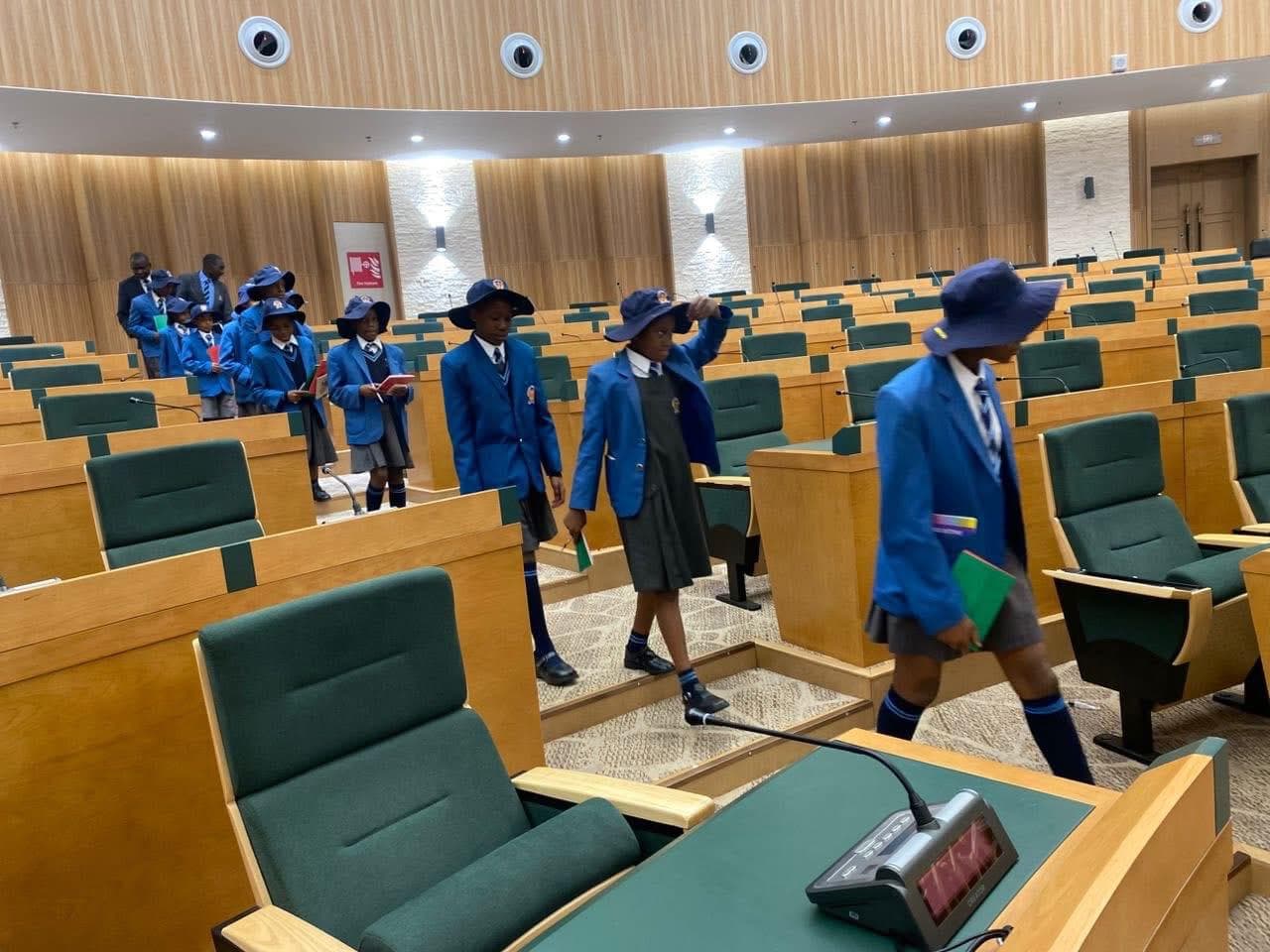 Harvard Junior pupils walking through the debating chamber of Zimbabwe’s Parliament